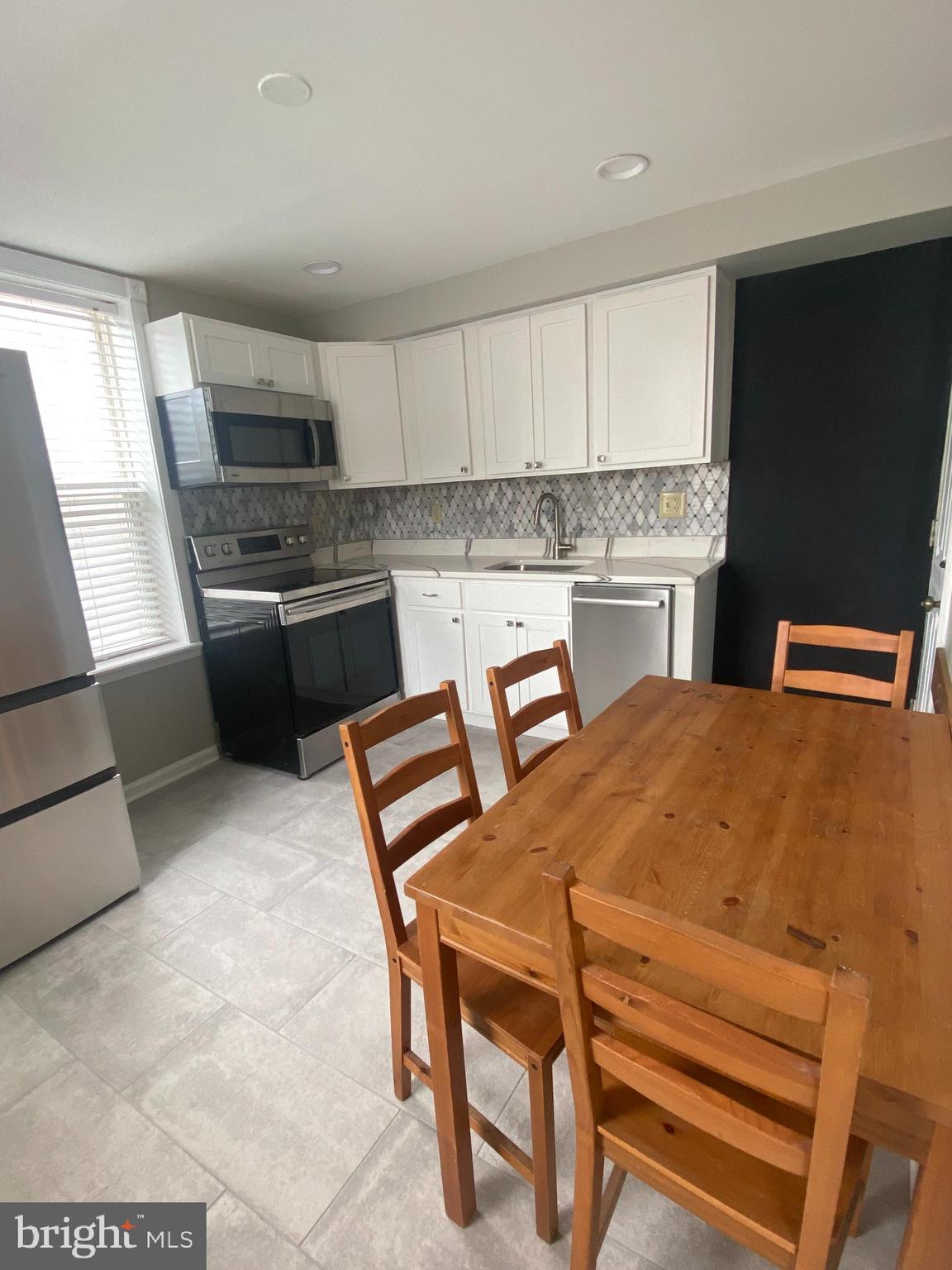 1458 Riverside Avenue, Unit 2C Baltimore, MD 21230 - Photo 3 of 14 a kitchen with cabinets and chairs