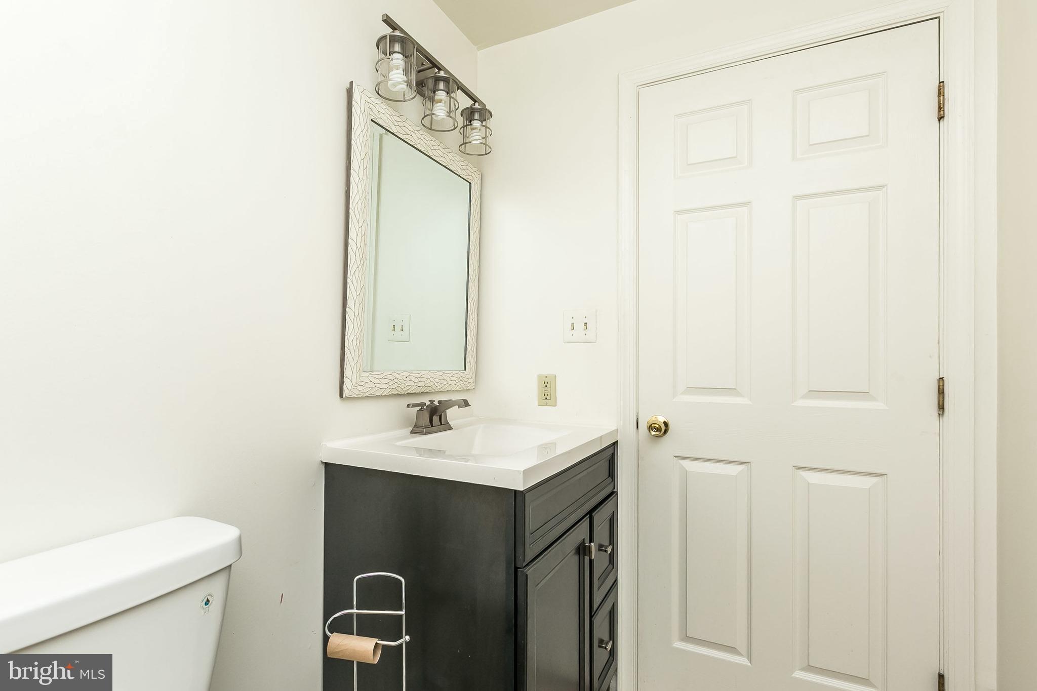 1458 Riverside Avenue, Unit 2C Baltimore, MD 21230 - Photo 7 of 14 a bathroom with a sink a toilet and mirror