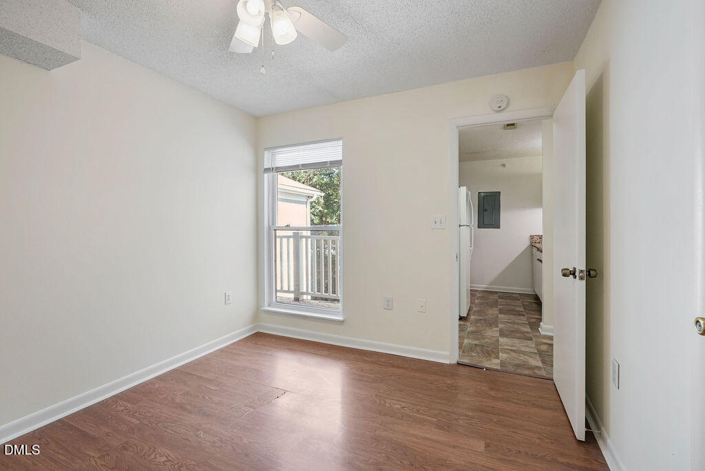 1411 Collegiate Circle, Unit 302 Raleigh, NC 27606 - Photo 12 of 43 an empty room with wooden floor fan and windows