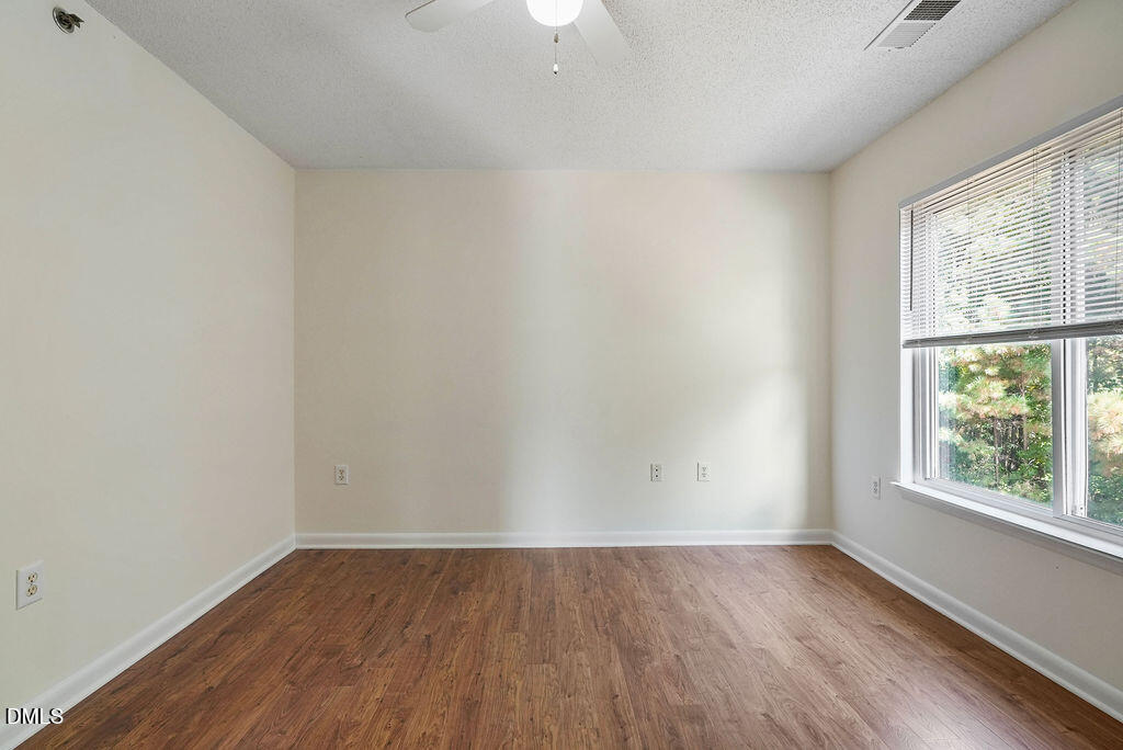 1411 Collegiate Circle, Unit 302 Raleigh, NC 27606 - Photo 19 of 43 an empty room with wooden floor and windows
