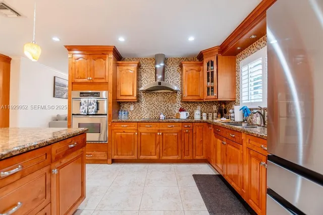 a large kitchen with stainless steel appliances granite countertop a stove a sink and a refrigerator