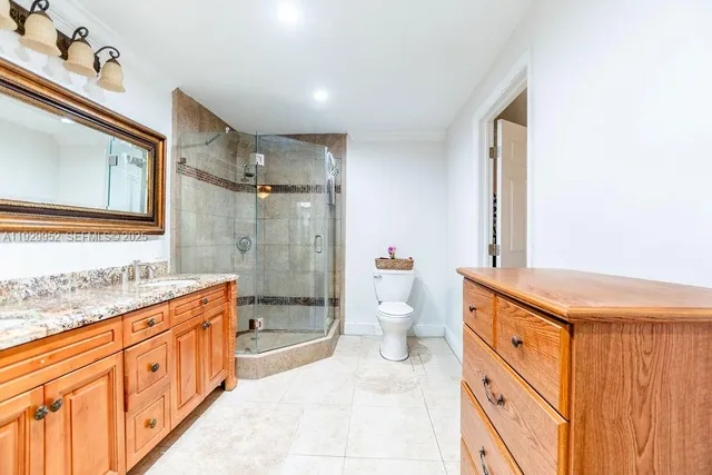 a spacious bathroom with a granite countertop sink mirror vanity and toilet