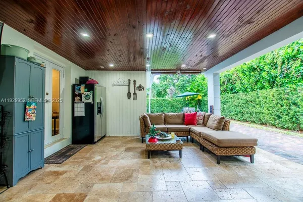 a living room with patio furniture and a potted plants