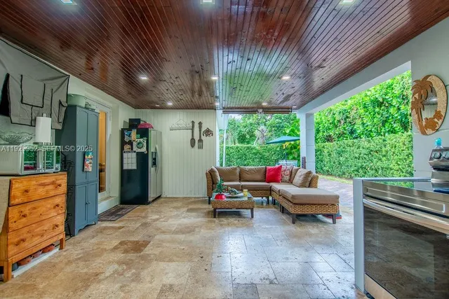 a living room with patio furniture and a floor to ceiling window