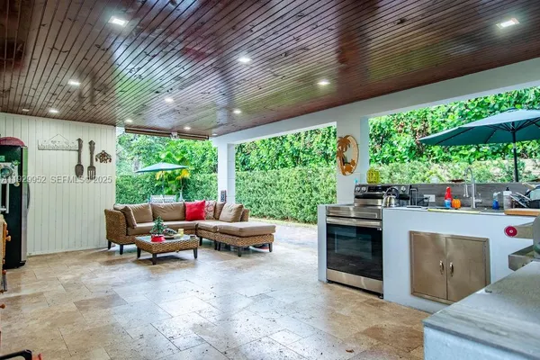 a living room with patio furniture and a floor to ceiling window