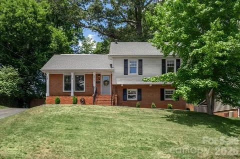 a front view of a house with a yard and trees