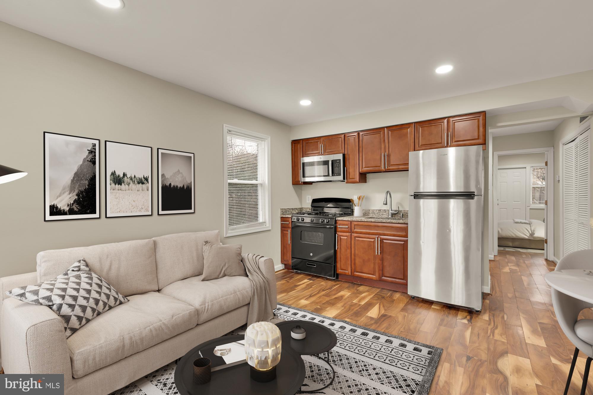 a living room with furniture and a refrigerator