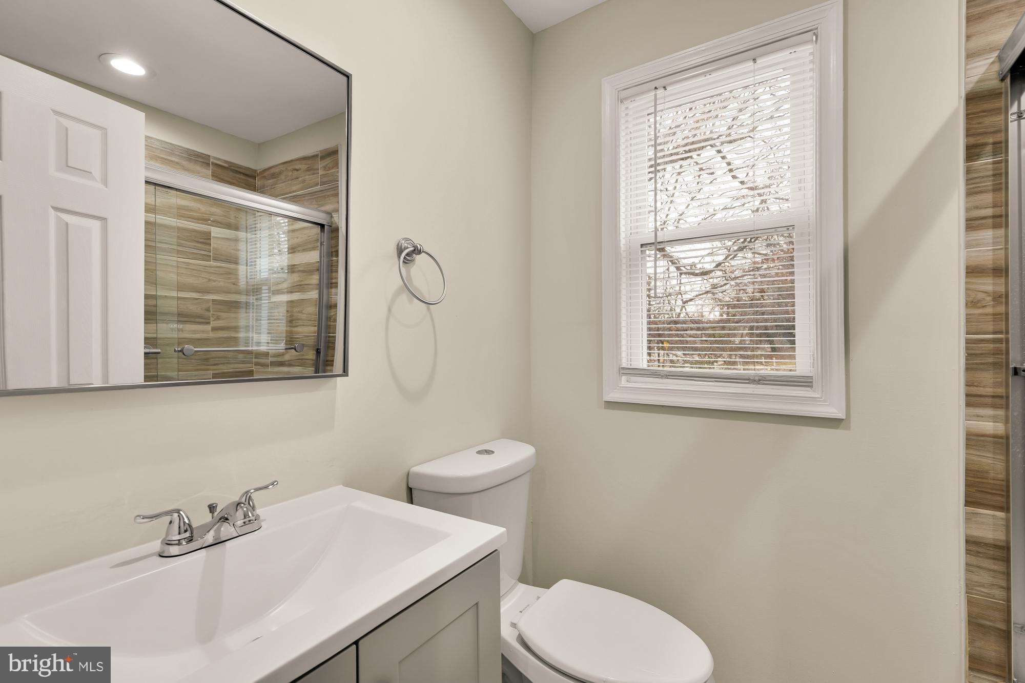 4131 Hunt Place Northeast, Unit A Washington, DC 20019 - Photo 5 of 9 a bathroom with a sink a toilet and a window