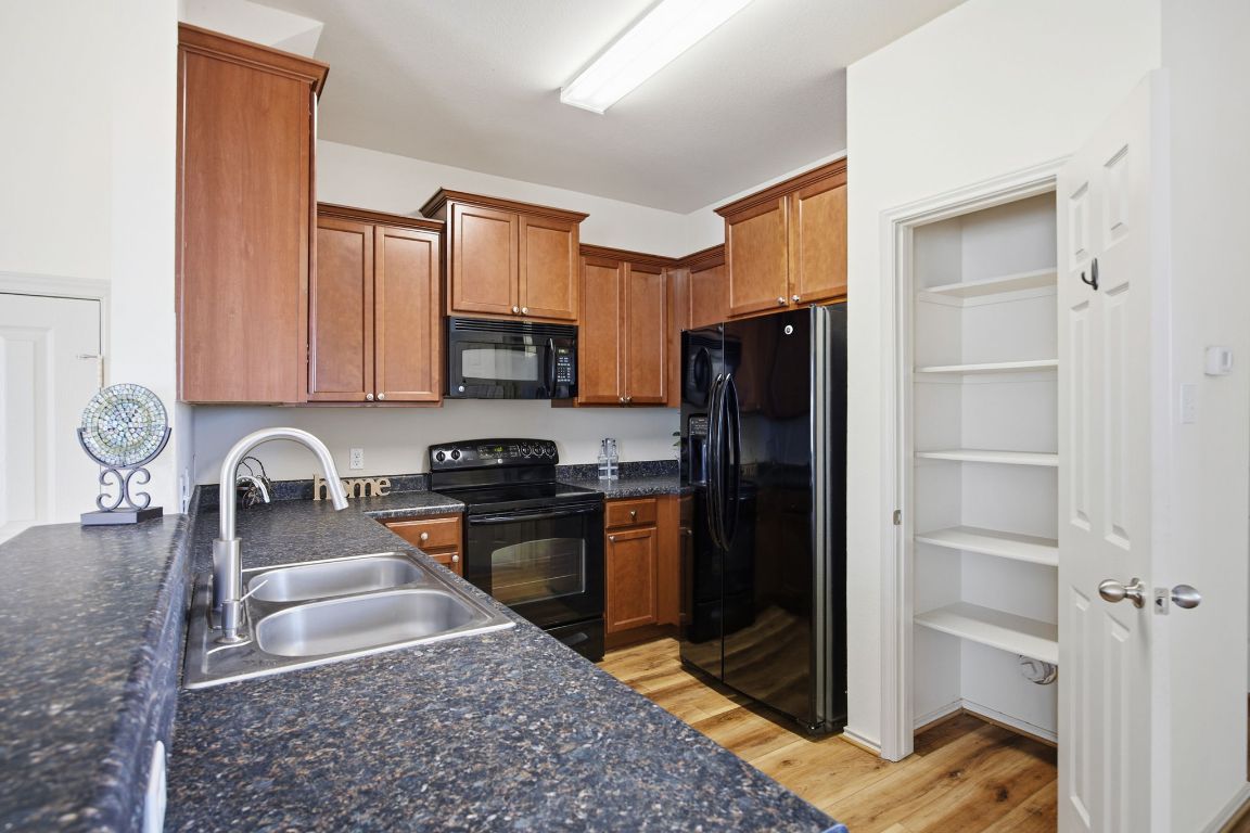 408 Azurite Drive Jarrell, TX 76537 - Photo 11 of 34 a kitchen with granite countertop a refrigerator and a sink