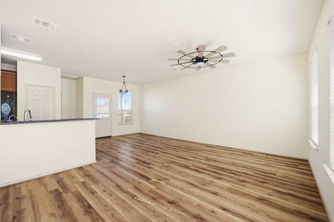408 Azurite Drive Jarrell, TX 76537 - Photo 3 of 34 a view of kitchen and empty room with wooden floor