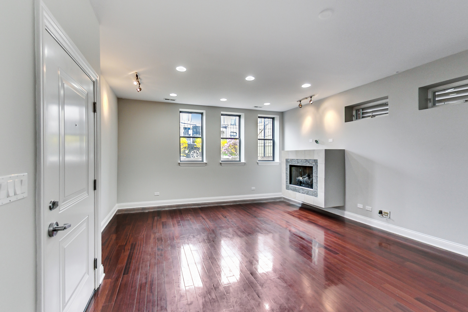 1231 East 46th Street, Unit GE Chicago, IL 60653 - Photo 3 of 16 an empty room with wooden floor and fireplace
