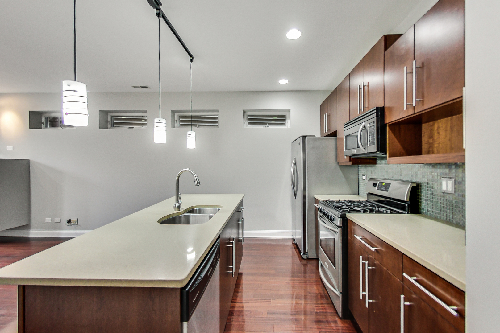 1231 East 46th Street, Unit GE Chicago, IL 60653 - Photo 6 of 16 a kitchen with stainless steel appliances a sink a stove a microwave a center island and cabinets