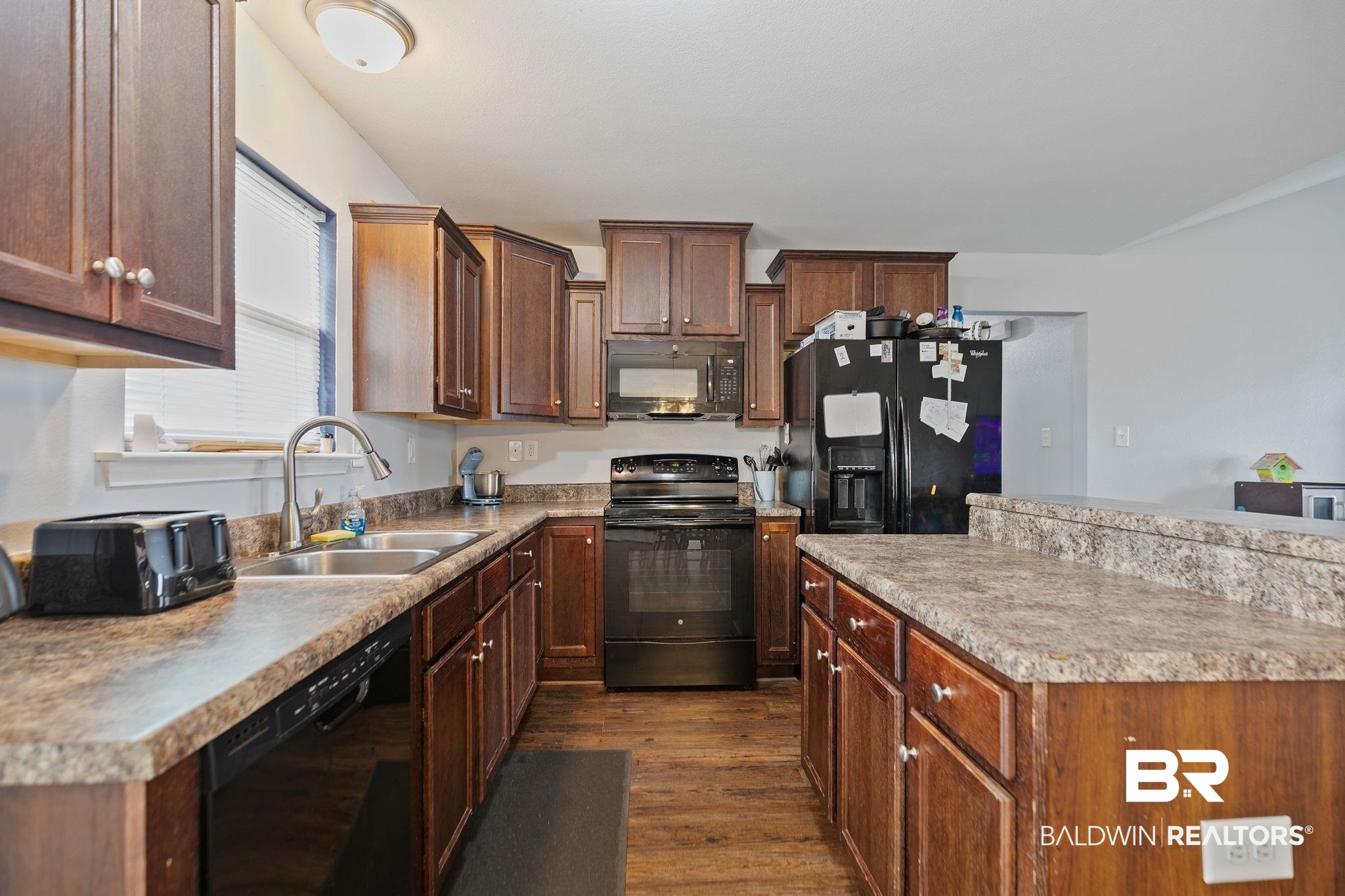15573 Talus Court Foley, AL 36535 - Photo 16 of 50 Kitchen featuring sink, dark hardwood / wood-style flooring, black appliances, and a kitchen island
