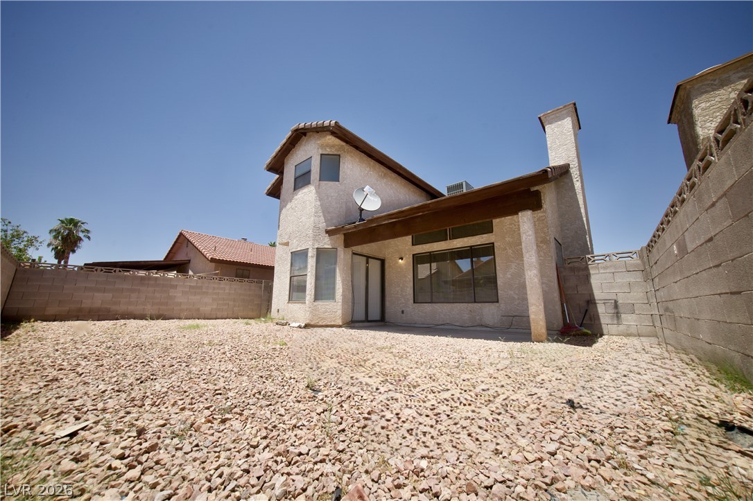 6501 Hartwood Road Las Vegas, NV 89108 - Photo 24 of 32 A spacious, gravel-filled backyard offers a private outdoor retreat behind a stucco-finished home.