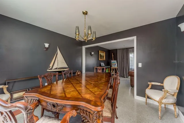 a open kitchen with stainless steel appliances granite countertop a stove top oven a sink dishwasher a dining table and chairs with wooden floor