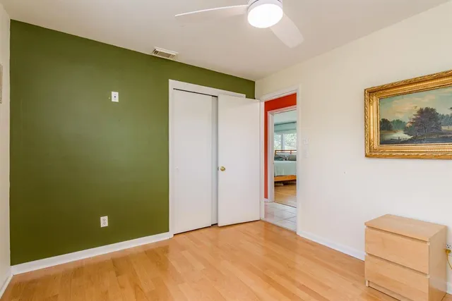a bedroom with a bed and a flat tv screen on dresser