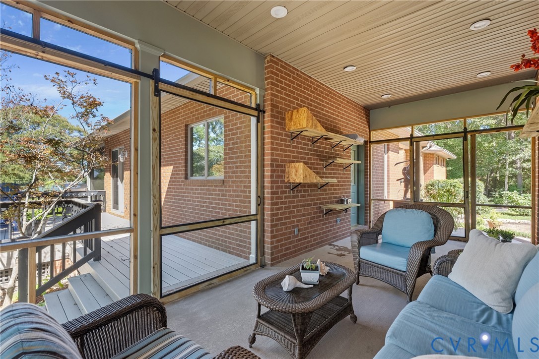 447 Tranquility Road Reedville, VA 22539 - Photo 63 of 82 Screened porch with brick wall, recessed lighting,