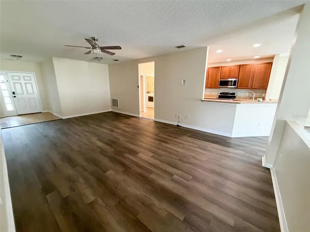 wooden floor in an empty room with a kitchen