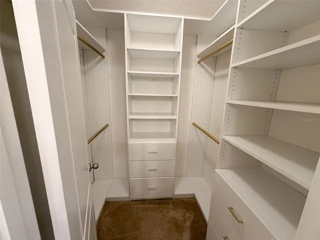 a view of walk in closet with empty racks