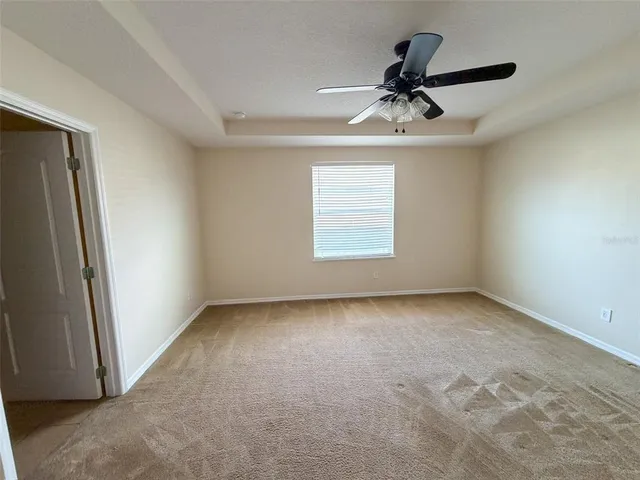 an empty room with a ceiling fan and window