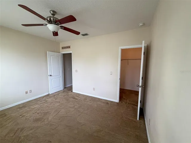 an empty room with a ceiling fan and a ceiling fan