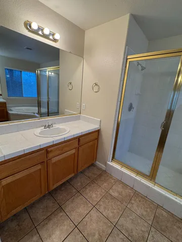 a spacious bathroom with a sink a mirror and a shower