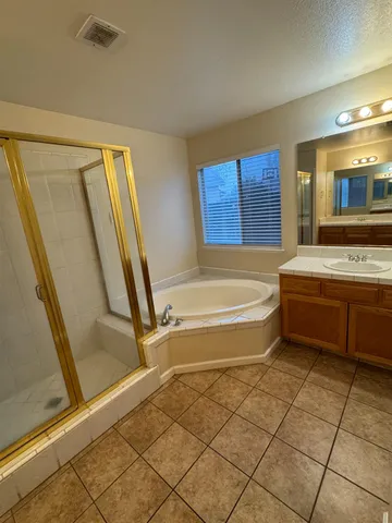a bathroom with a tub a sink and a mirror