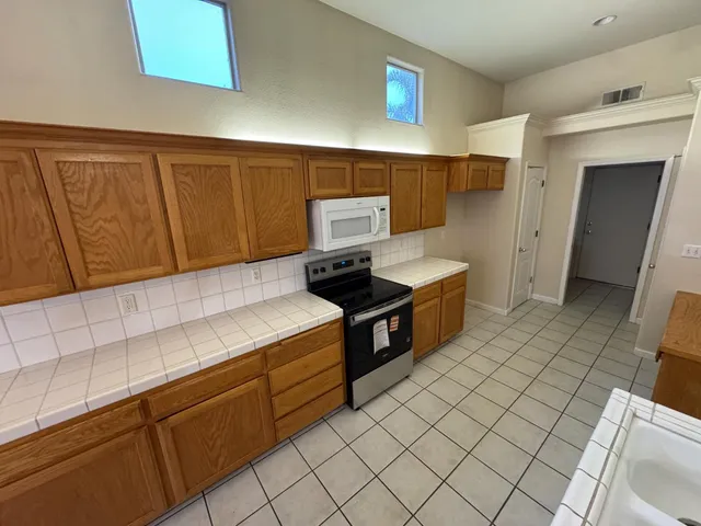 a kitchen with stainless steel appliances granite countertop a sink and a stove