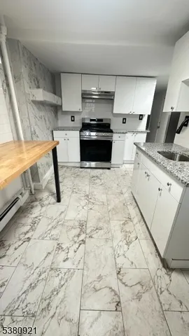 a kitchen with granite countertop a sink and a stove
