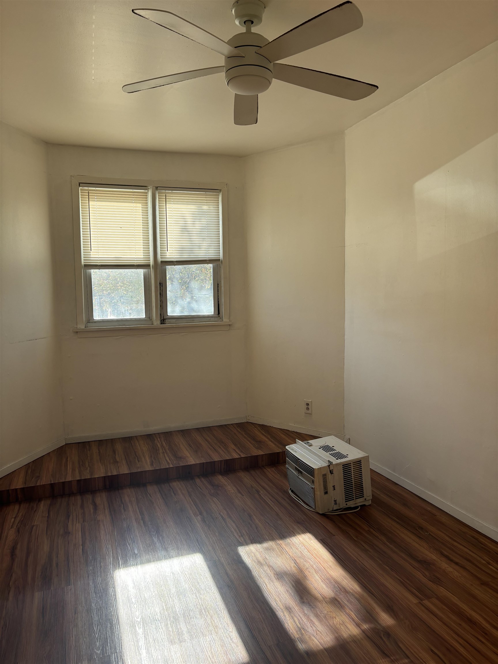 407 John F. Kennedy Boulevard, Unit 1 Bayonne, NJ 07002 - Photo 3 of 7 an empty room with wooden floor and windows