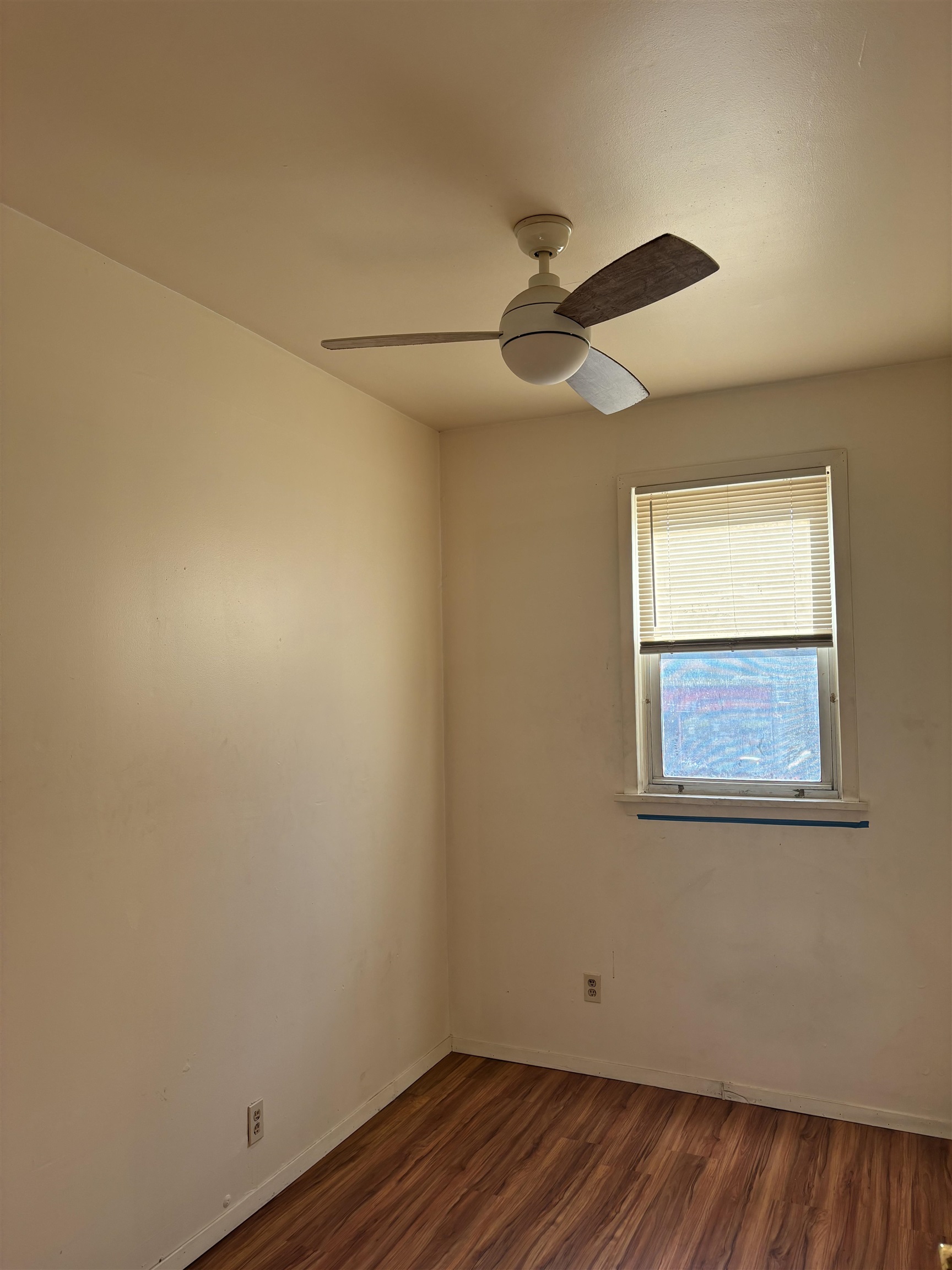 407 John F. Kennedy Boulevard, Unit 1 Bayonne, NJ 07002 - Photo 4 of 7 a view of an empty room with wooden floor and a window