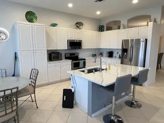 a kitchen with stainless steel appliances a microwave sink refrigerator and cabinets