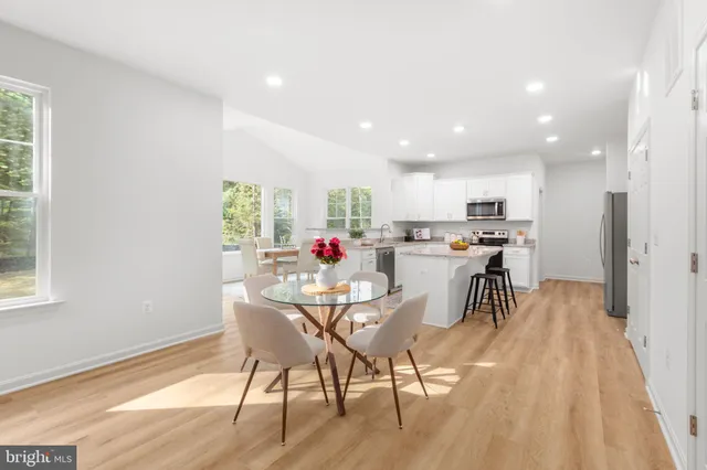 a view of a dining room with furniture a kitchen and chandelier