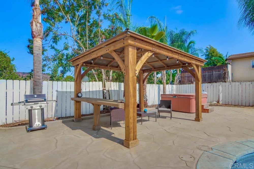 9201 Shadow Hill Road Santee, CA 92071 - Photo 28 of 30 a view of a patio with table and chairs under an umbrella with a barbeque grill and plants