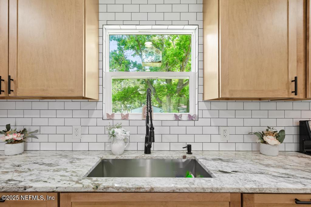 54308 Hurst Road Callahan, FL 32011 - Photo 17 of 49 a bathroom with a granite countertop sink and a window