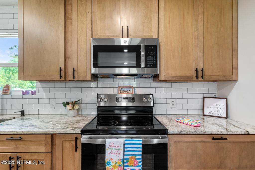 54308 Hurst Road Callahan, FL 32011 - Photo 20 of 49 a kitchen with stainless steel appliances wooden cabinets and a stove top oven