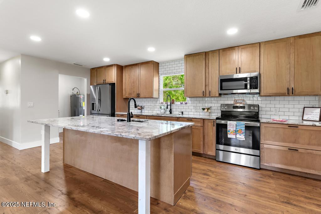 54308 Hurst Road Callahan, FL 32011 - Photo 25 of 49 a kitchen with stainless steel appliances granite countertop a stove a sink and a microwave