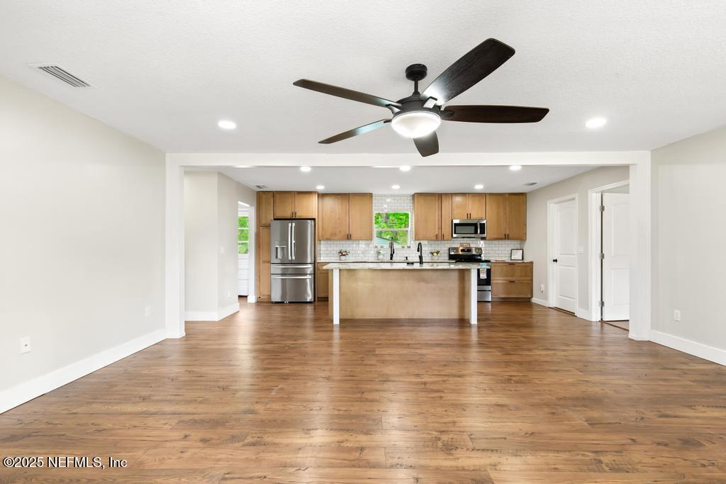 54308 Hurst Road Callahan, FL 32011 - Photo 7 of 49 a view of an empty room and kitchen with chandelier fan