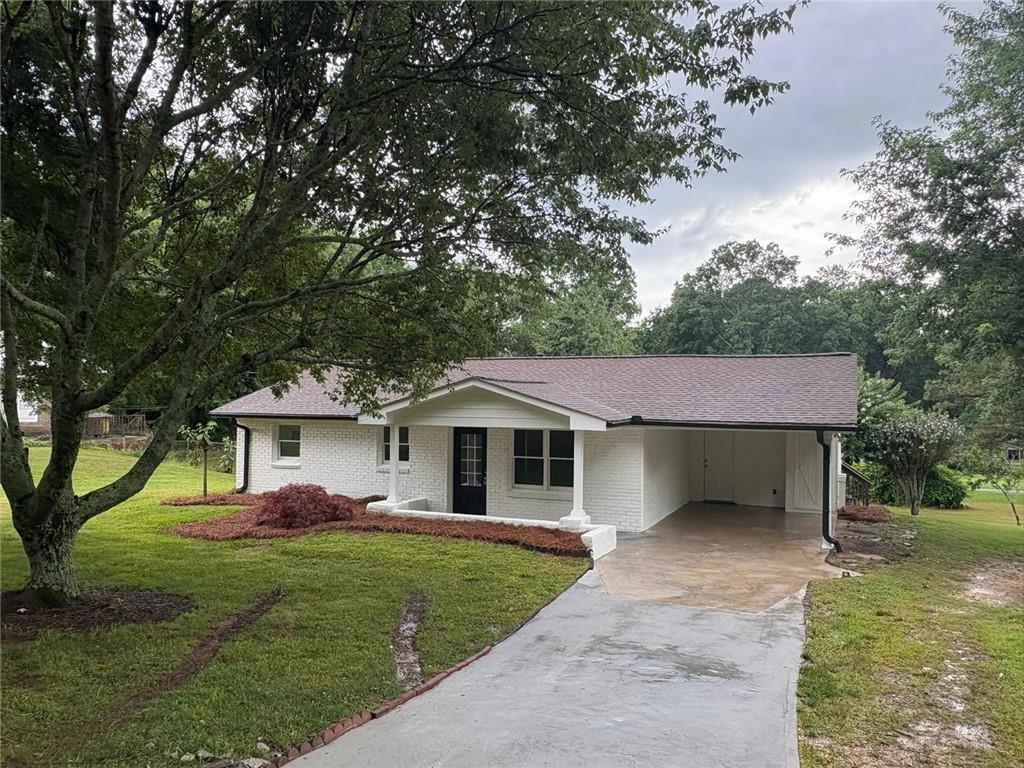 a front view of a house with a garden and yard