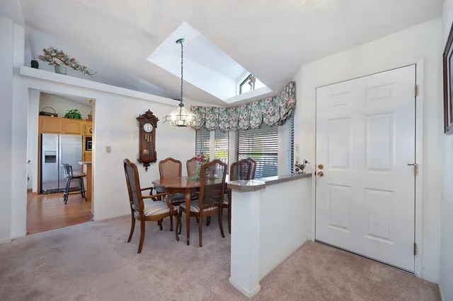 a dining room with furniture a chandelier and wooden floor