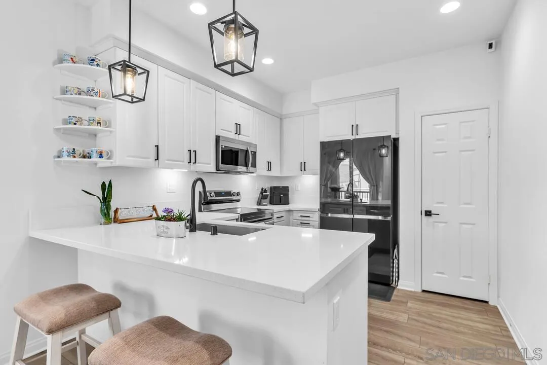 2811 Safflower Street Spring Valley, CA 91977 - Photo 3 of 28 a kitchen with stainless steel appliances a sink a stove a refrigerator cabinets and a dining table