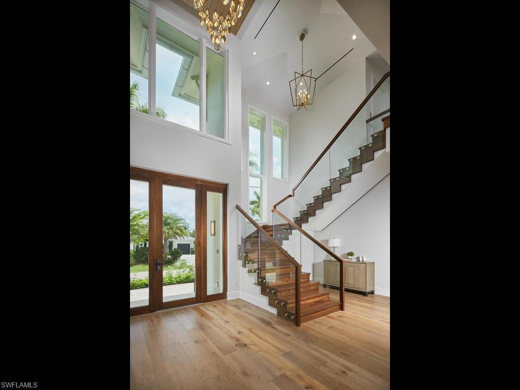 575 17th Avenue South Naples, FL 34102 - Photo 20 of 43 Foyer entrance with an inviting chandelier, a high ceiling, and hardwood / wood-style flooring