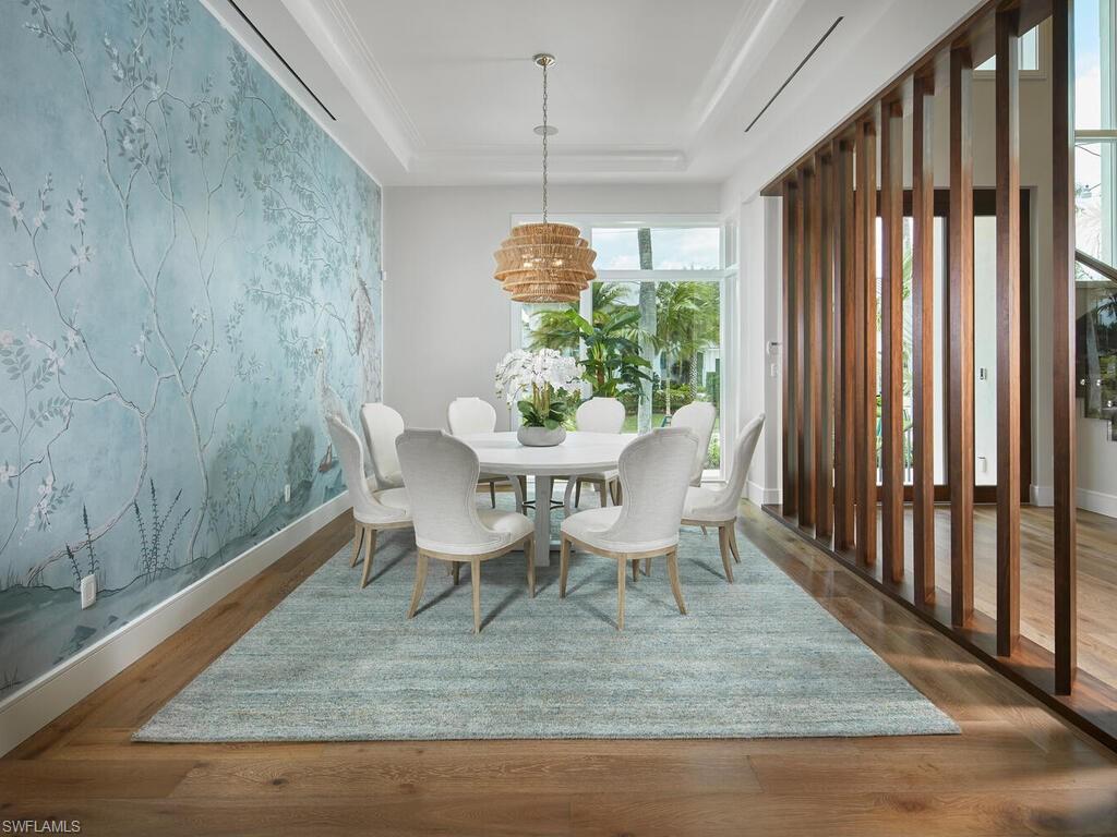 575 17th Avenue South Naples, FL 34102 - Photo 9 of 43 Dining space with a tray ceiling and dark wood-type flooring