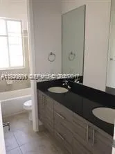 a bathroom with a granite countertop sink a toilet and bathtub