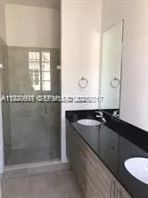 a bathroom with a granite countertop sink a mirror and a bathtub