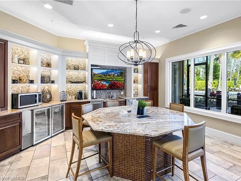 10840 Rutherford Road Fort Myers, FL 33913 - Photo 35 of 35 Tiled dining room with built in shelves, an inviting chandelier, and wine cooler