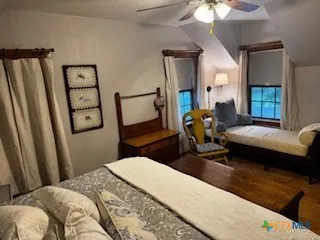 a bedroom with a bed couch and a window