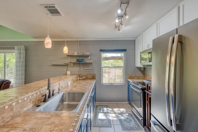 a kitchen with stainless steel appliances granite countertop a sink stove and refrigerator