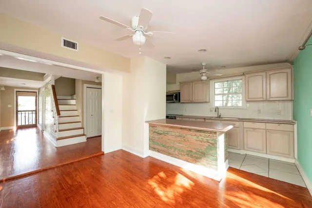 a large kitchen with cabinets and wooden floor