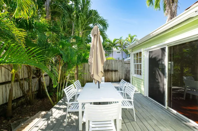 a view of a patio with table and chairs potted plants with wooden floor and fence